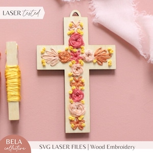 May include: A wooden cross with a floral embroidery design in shades of pink, orange, and yellow. The cross is laser cut and ready for embroidery. "LASER tested" and "SVG LASER FILES | Wood Embroidery" are printed on the image.