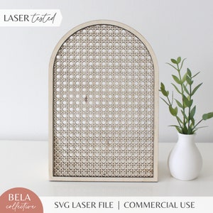 Pode incluir: Um arco de madeira cortado a laser com um padrão de vime tecido. O arco é feito de madeira natural e tem uma cor castanho claro. O arco está sobre uma superfície branca. O texto "LASER tested" é visível no canto superior esquerdo da imagem. O texto "SVG LASER FILE | COMMERCIAL USE" é visível na parte inferior da imagem.