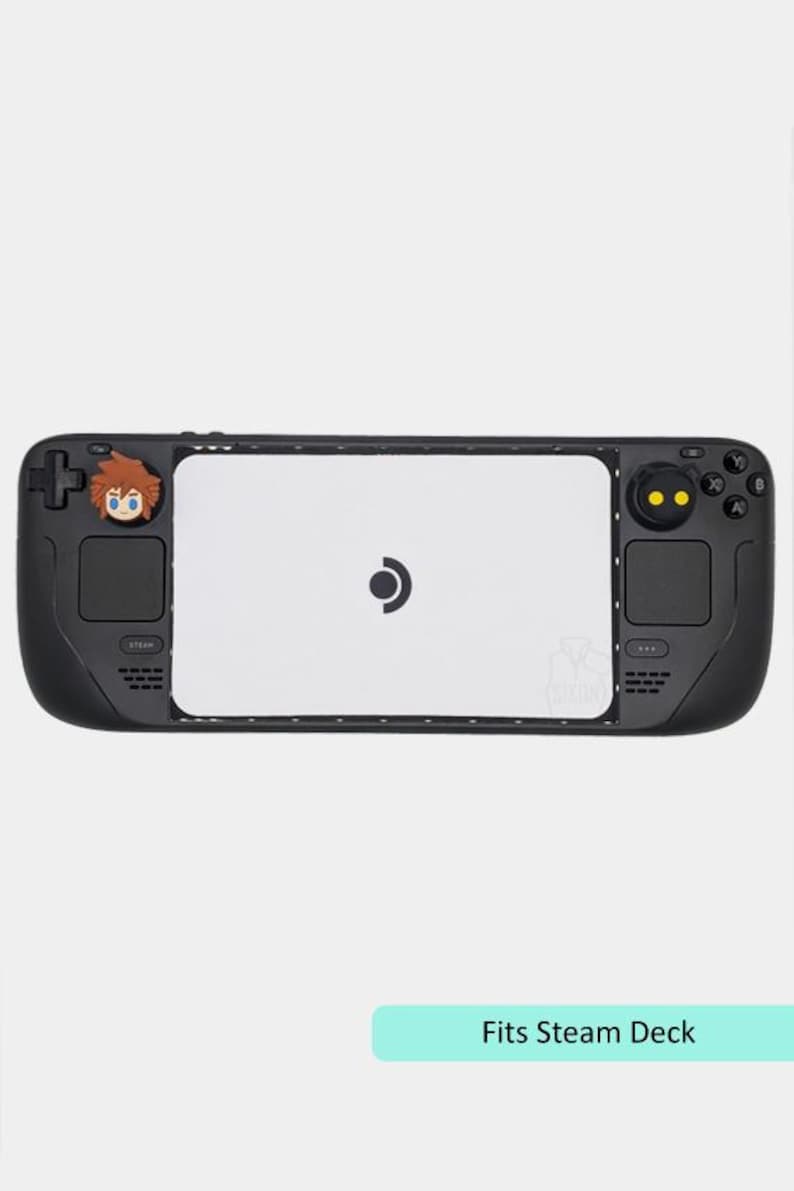 May include: Black Steam Deck console with a white center panel and a character design on the left side. The console has buttons and a joystick on both sides. The text "Fits Steam Deck" is at the bottom.