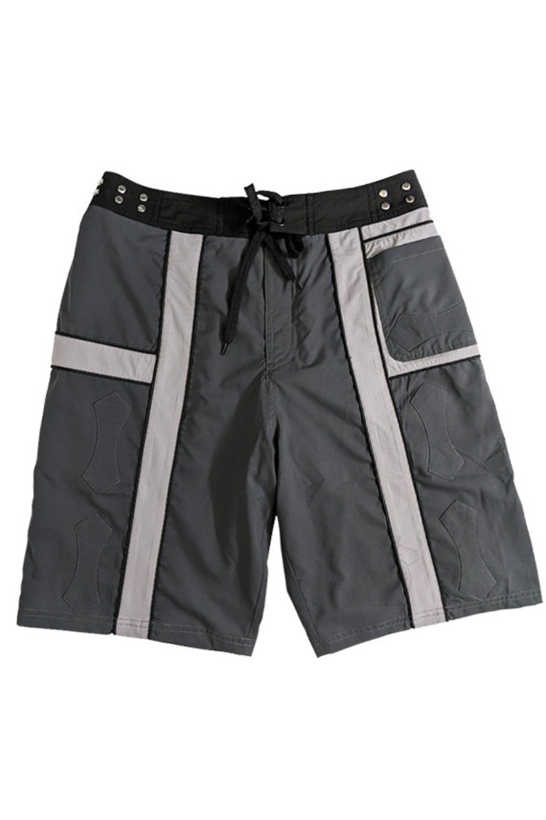 May include: Gray and black swim trunks with white reflective stripes and a black drawstring. The trunks have a pocket on the right side.