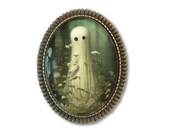 May include: An oval brooch with a textured bronze-toned metal frame containing a glass cabochon. The image inside depicts a white ghost-like figure holding yellow flowers in a dark forest setting with the text 843 BEEHIVE LANE visible.