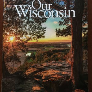 May include: A magazine cover with a sunset scene featuring a large tree with a thick trunk and branches. The magazine is titled "Our Wisconsin" with the August/September 2017 issue date and a price of $5.00.