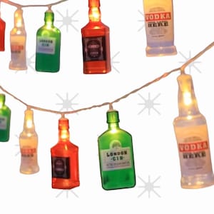 Könnte beinhalten: Lichterkette mit Miniatur-Glühbirnen in Flaschenform. Die Flaschen sind klar, grün und rot mit Etiketten, auf denen "Vodka Here", "London Gin" und "Vodka Here" steht.