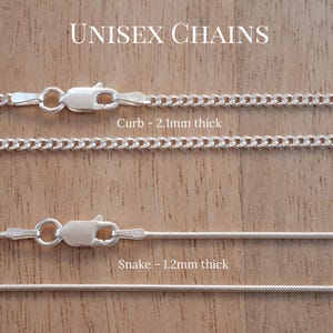 May include: Two silver-toned metal chains labelled Unisex Chains. The top chain is a curb style measuring 2.1mm thick with a lobster claw clasp. The bottom chain is a snake style measuring 1.2mm thick with a lobster claw clasp.