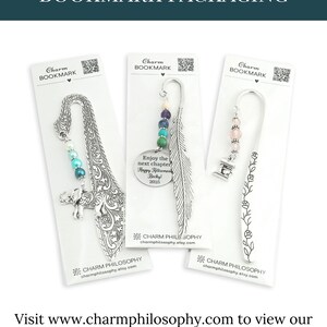 three charm bookmarks packaged in white paper, each featuring a unique design and color scheme.