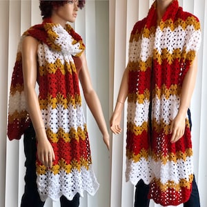 May include: A crocheted scarf with red, white, and gold stripes. The scarf is made with a lacy stitch and has a scalloped edge.
