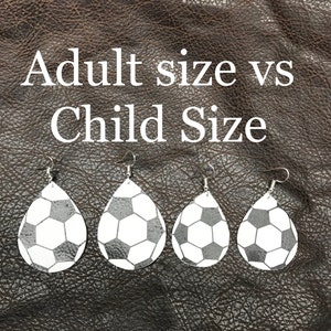 Peut inclure: Gros plan sur quatre paires de boucles d'oreilles en forme de ballon de football. Les boucles d'oreilles sont de deux tailles, adulte et enfant. Les boucles d'oreilles pour adultes sont plus grandes que les boucles d'oreilles pour enfants.