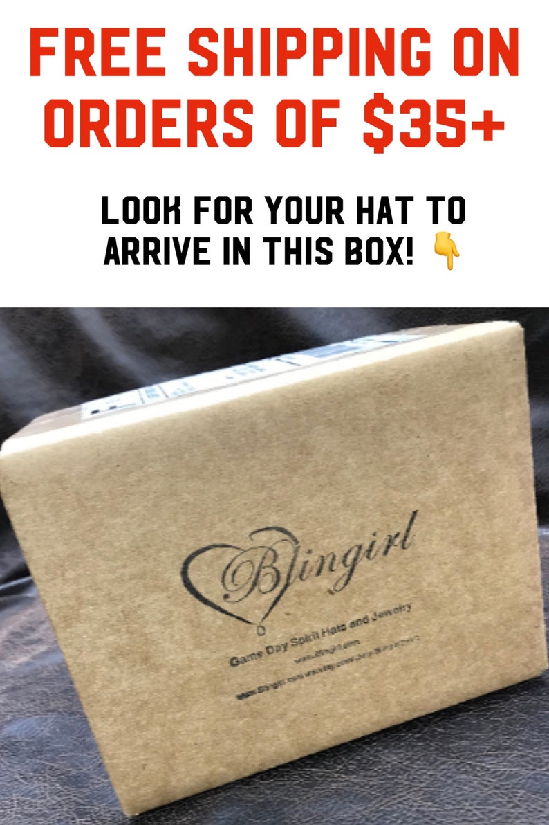 May include: A brown cardboard box with the text "Blingirl" and "Game Day Spirit Hats and Jewelry" printed on it. The box is sitting on a brown surface. Free shipping on orders of $35+.