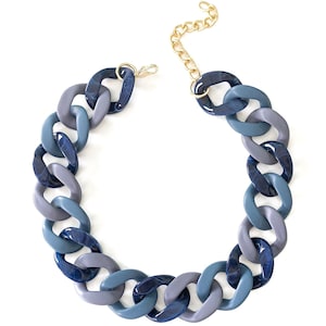May include: A chunky blue, gray, and dark blue plastic chain necklace with a gold clasp.