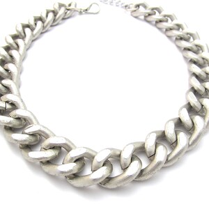May include: A silver chain necklace with a chunky, thick link design.