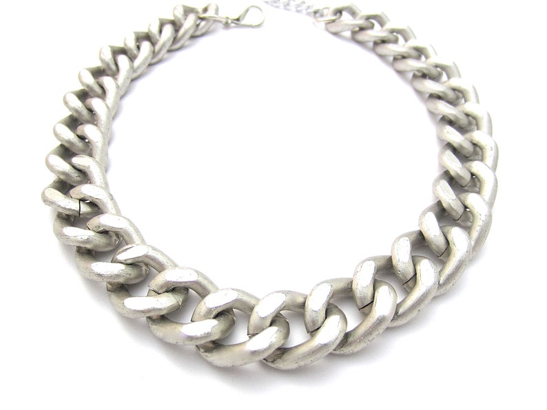 May include: A silver chain necklace with a chunky, thick link design.