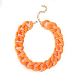 May include: A bright orange chunky chain necklace with a gold clasp.