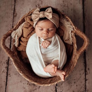 Newborn Photography Session with baby asleep wearing oversized fabric bow headband