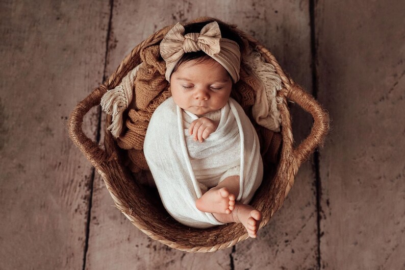 Newborn Photography Session with baby asleep wearing oversized fabric bow headband