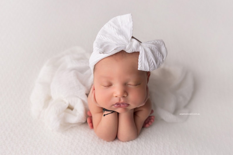 Newborn Photography Session with baby asleep wearing oversized fabric bow headband