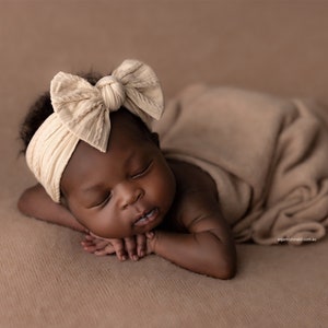 Newborn Photography Session with baby asleep wearing oversized fabric bow headband