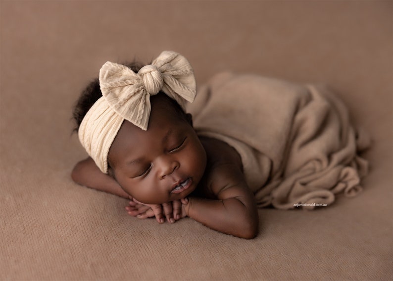 Newborn Photography Session with baby asleep wearing oversized fabric bow headband