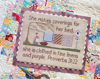 May include: A cross-stitch sampler with a verse from Proverbs 31:22, "She makes coverings for her bed, she is clothed in fine linens and purple. Proverbs 31:22". The sampler depicts a woman hanging quilts on a clothesline.