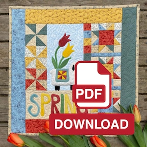 May include: A colorful quilt block with a spring theme. The block features a patchwork design with a variety of fabrics in red, yellow, blue, and green. The center of the block features a white lamb carrying a basket of yellow tulips. The word "SPRING" is written in colorful letters below the lamb. A PDF download button is in the foreground.