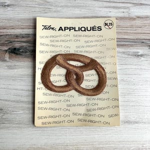 May include: A handmade wooden sign displaying the word "Welcome" in a handwritten font. The sign is painted white with a distressed finish, and a small green leaf is attached. Ideal for home decor.