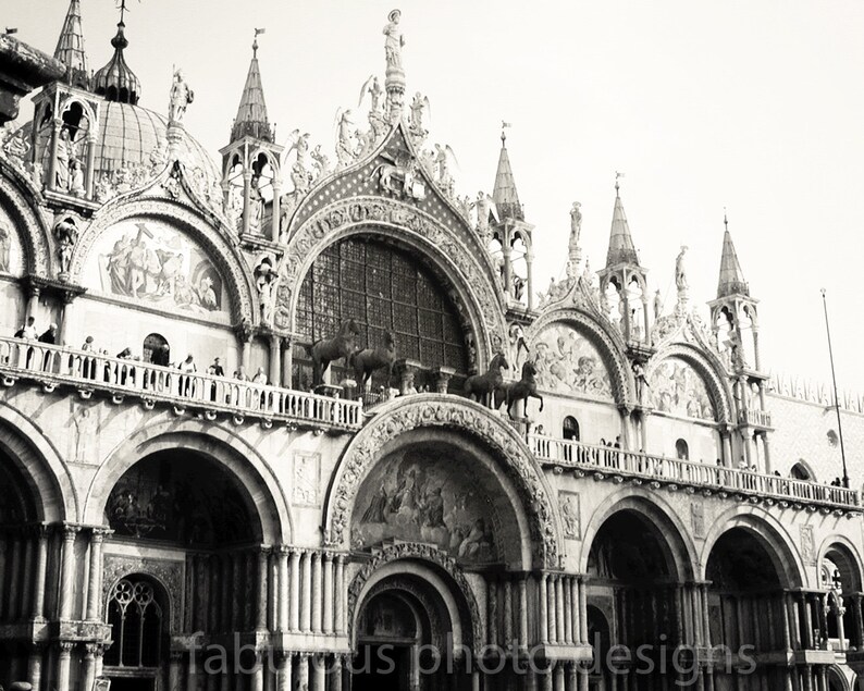 May include: A black and white photograph of a large, ornate building with multiple arches and spires. The building has a complex design with intricate details and a balcony with a railing.