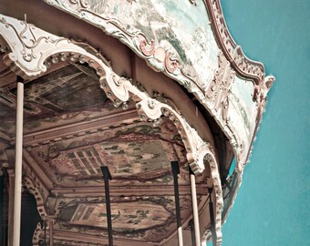 May include: A vintage carousel with faded paint and intricate details. The carousel is made of wood and metal and has a white and blue painted roof. The carousel is in a state of disrepair, but it still has a sense of charm and nostalgia.