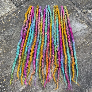 May include: A set of three ceramic mugs with a speckled, matte finish. The mugs are in shades of blue, green, and white. Each mug has a rounded handle and a simple, modern design. The mugs are likely for coffee or tea.