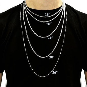 May include: A silver chain necklace is shown on a model wearing a black shirt. The chain is shown in five different lengths: 18 inches, 20 inches, 24 inches, 30 inches, and 36 inches.