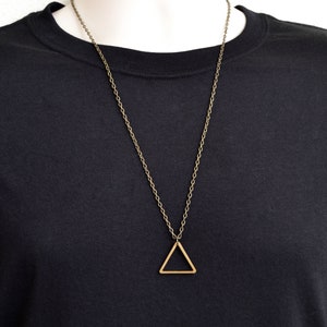 Peut inclure: Un collier en cha&icirc;ne dor&eacute;e avec un pendentif en forme de triangle simple.