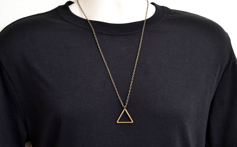 Peut inclure: Un collier en cha&icirc;ne dor&eacute;e avec un pendentif en forme de triangle simple.