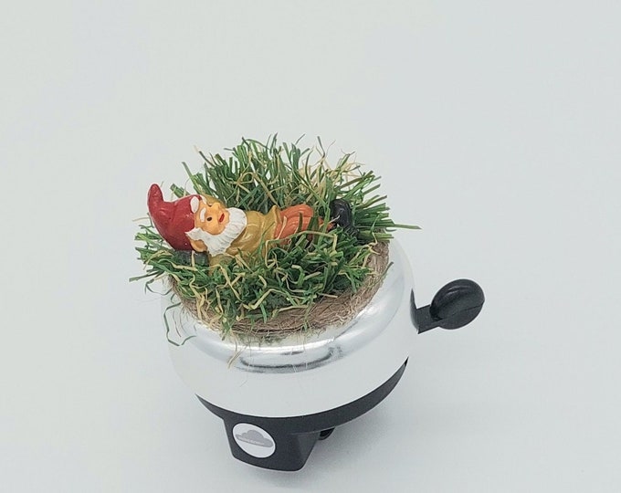Bicycle bell with garden gnome on artificial turf