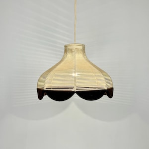May include: A white and brown woven pendant light with a scalloped bottom edge.