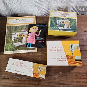 May include: A collection of vintage Singer sewing machine manuals and accessory boxes, including a Golden Touch & Sew instruction booklet, a Professional Buttonholer box, a Circular Stitcher box, and a small Professional Buttonholer instruction manual.