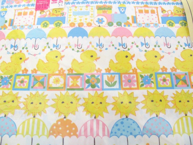 May include: A yellow and white wrapping paper with a repeating pattern of ducks, umbrellas, suns, and flowers. The paper also features a train with a yellow, blue, and red color scheme.