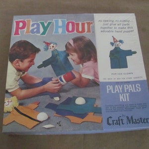 May include: A vintage Play Hour Craft Master Play Pals Kit box featuring a clown puppet. The box has a blue background with colorful text and images of children making the puppet. The kit includes all the materials needed to make the puppet, including felt pieces, glue, and instructions.