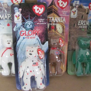 May include: Four Ty Beanie Babies in their original packaging. The bears are named Map, Glory, Tarnia, and Erin. Each bear is wearing a different country's flag on their chest. The bears are white, brown, and green.