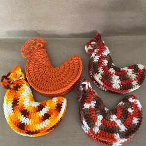 May include: Four crocheted chicken-shaped pot holders in orange, brown, white, and yellow.