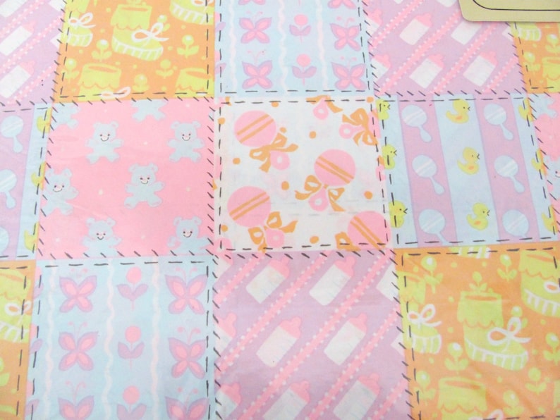 May include: A patchwork fabric with a variety of pastel colors and patterns, including baby animals, flowers, and toys. The fabric is perfect for quilting, sewing, or crafting.