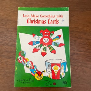 May include: A green booklet with the title "Let's Make Something with Christmas Cards" and a colorful illustration of a Christmas ornament and a snowman. The booklet is a Pack-o-Fun publication and costs 50 cents.