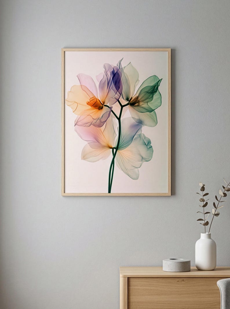 May include: A framed floral art print featuring a delicate botanical illustration. The artwork showcases translucent flowers in shades of orange, pink, purple, and green against a light background. The frame is made of light-colored wood.