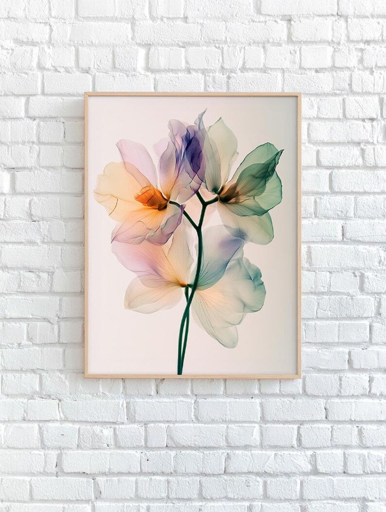 May include: A framed print featuring a close-up of translucent flowers in shades of orange, pink, purple, and green. The delicate petals are arranged on a dark green stem. The artwork is displayed against a white background.