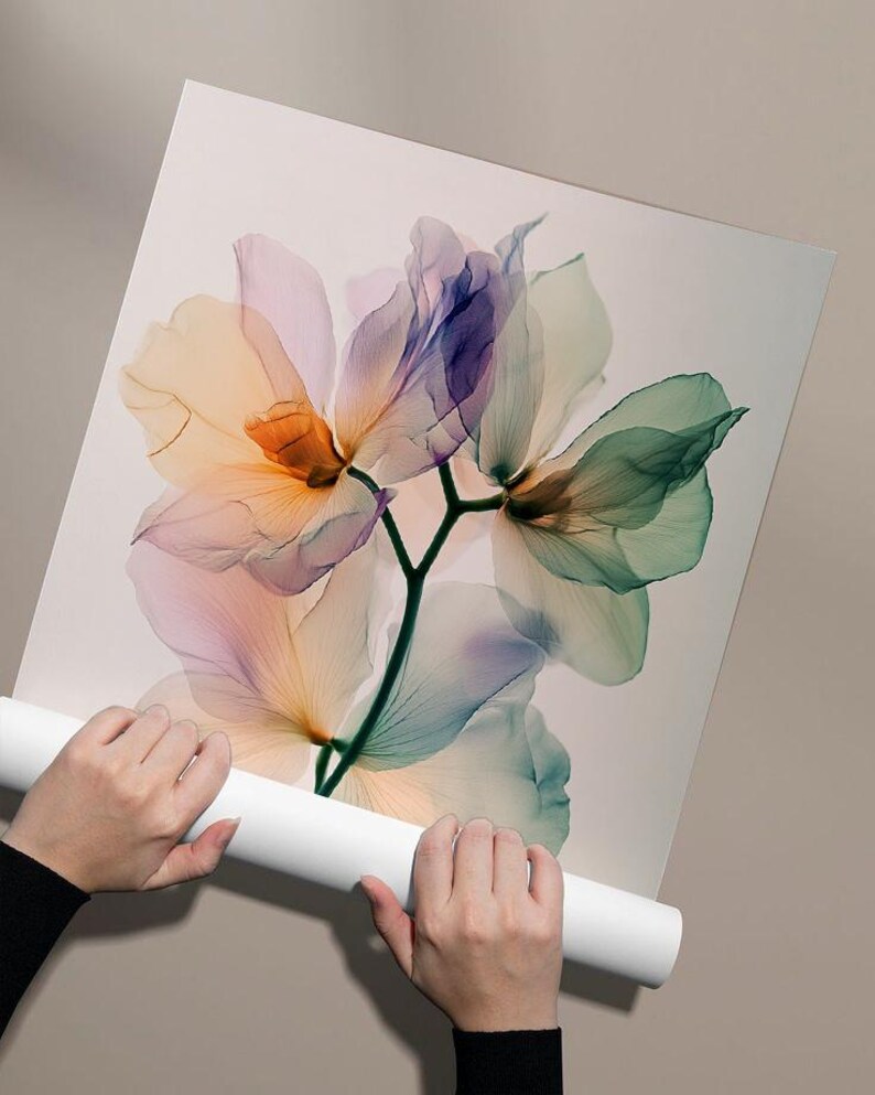 May include: A floral art print featuring translucent flowers in shades of orange, pink, purple, and green. The delicate petals are set against a white background. The print is held by a person.