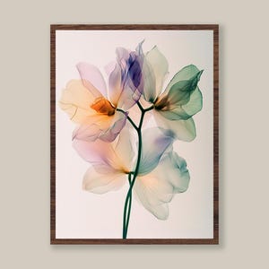 May include: A framed print featuring a close-up of delicate, translucent flowers in shades of orange, pink, purple, and green. The floral arrangement is set against a soft, off-white background, encased in a dark brown wooden frame.