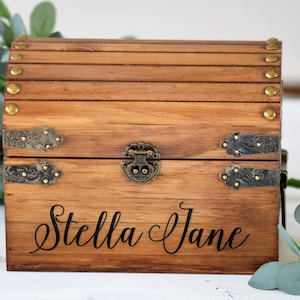 May include: A wooden treasure chest with a hinged lid, brass accents, and the name "Stella Jane" engraved on the front.