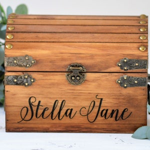 May include: A wooden treasure chest with a hinged lid, brass accents, and the name "Stella Jane" engraved on the front.