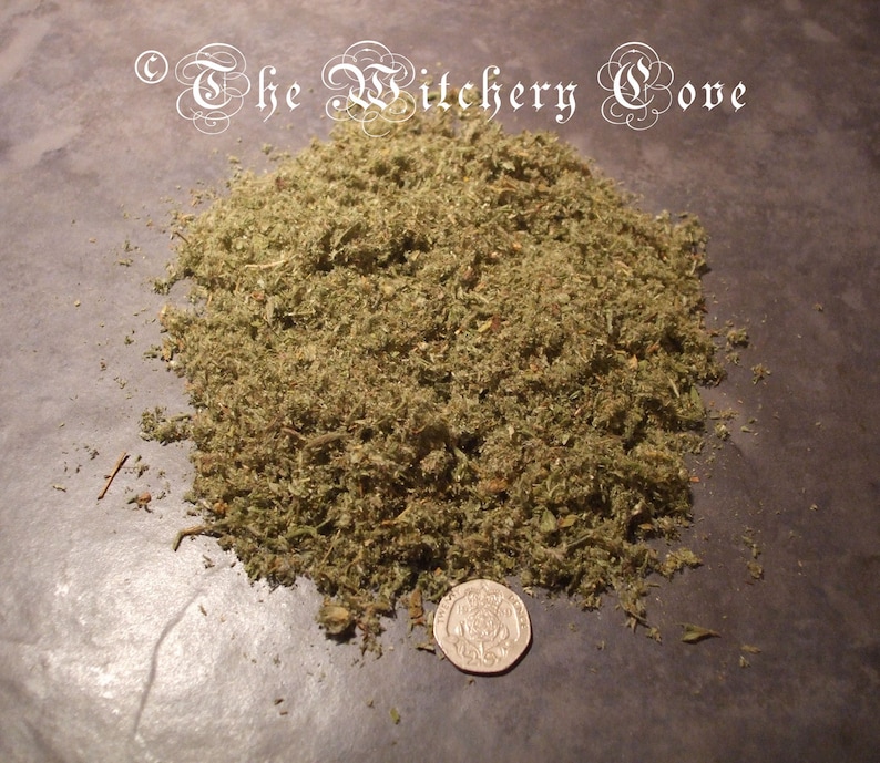 May include: A pile of dried, green herbs with a coin for scale. The herbs are finely chopped and appear to be a mix of leaves and stems. The text "The Witchery Cove" is in the upper left corner.
