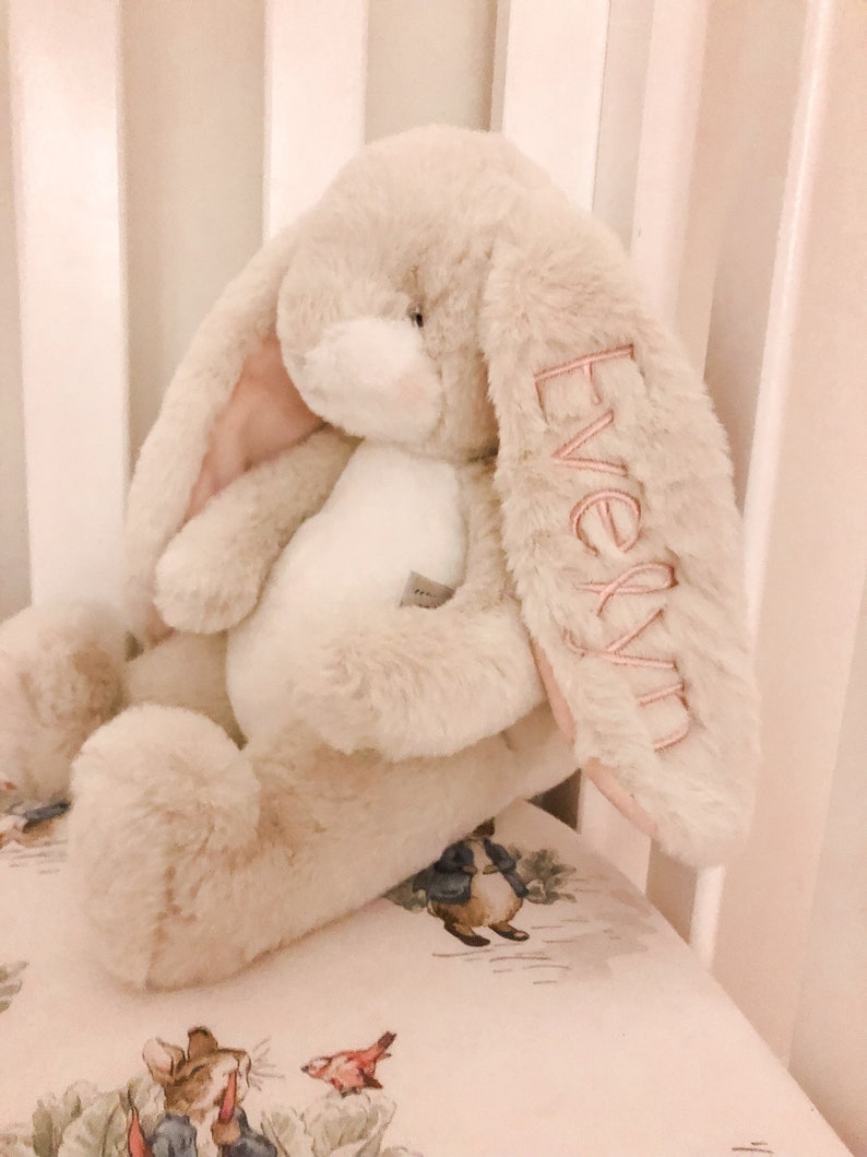 Monogrammed stuffed bunny with name on the ear. Cream bunny shown with pink monogram