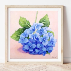 May include: A painting of a blue hydrangea flower with green leaves on a pink background. The painting is framed in a light wood frame.