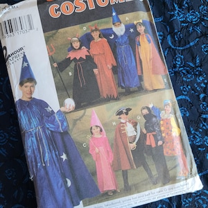 May include: A Simplicity sewing pattern for children's costumes. The pattern includes eight different costumes: a wizard, a devil, a princess, a pirate, a ninja, a clown, a fairy, and a witch. The pattern is for sizes S, M, and L.