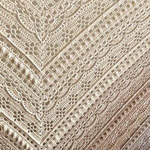 May include: A crocheted shawl with a delicate, lacy pattern in a gradient of beige and brown colors.